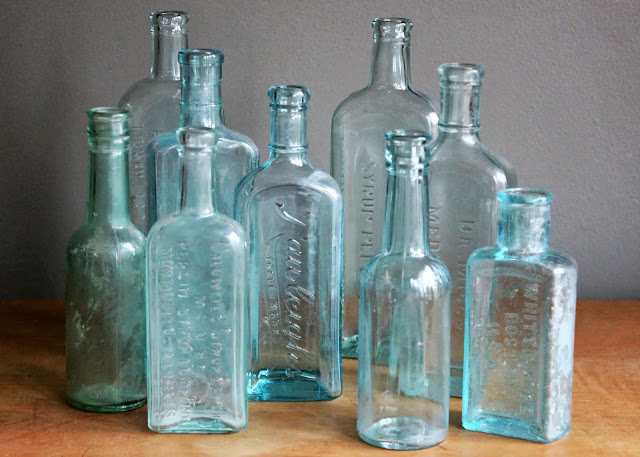 Assorted aqua medicine bottles available for rent from www.momentarilyyours.com, $1.25 each.